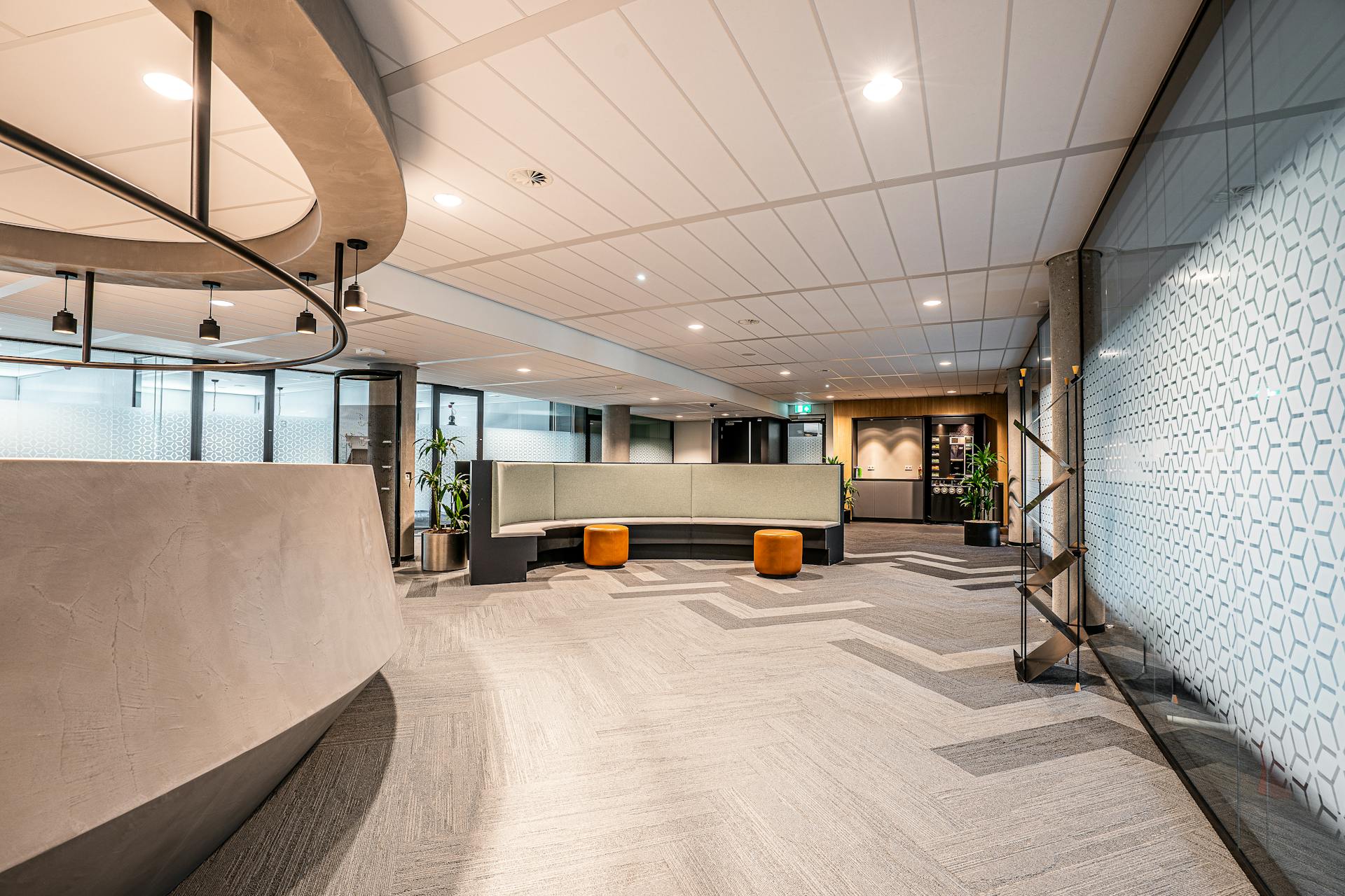Spacious modern office lobby featuring minimalist interior design with seating and decorative lighting.