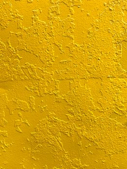Bright yellow stucco wall with rich texture for creative backgrounds or design elements.