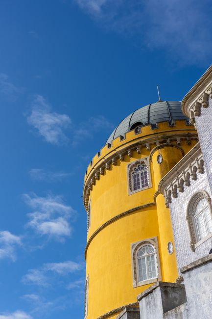The yellow and white domes of Pena Palace rising above the treeline in Sintra