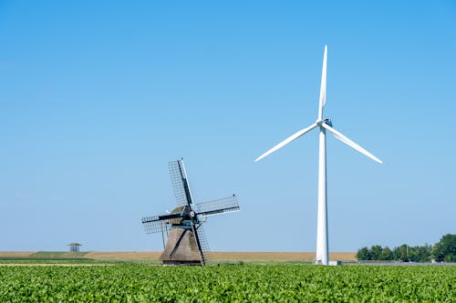 Windmill and a Wind Turbine on a Field 