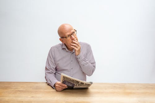 Free Man in Gray Long Sleeve Shirt Holding a Newspaper Stock Photo