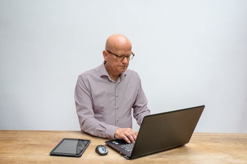 An Elderly Man Focus Working with a Laptop