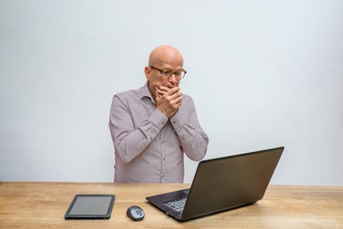 Free Man in Gray Long Sleeve Shirt in Front of Laptop Stock Photo