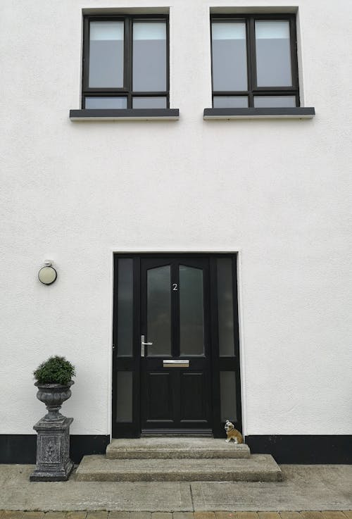 Free A Black Door on White House with Windows Stock Photo
