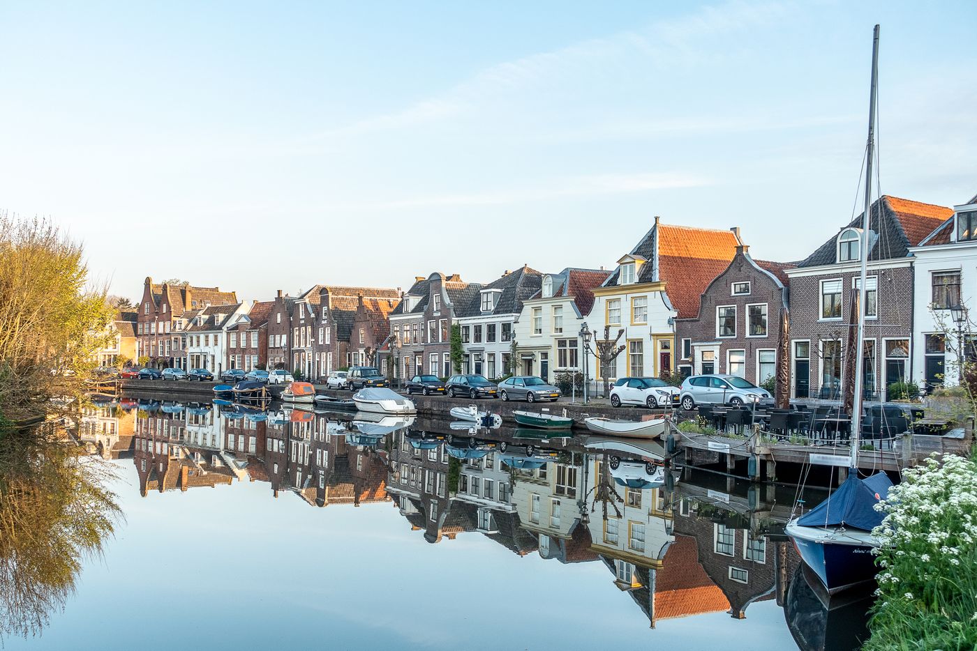 Boats moored on a river between town buildings