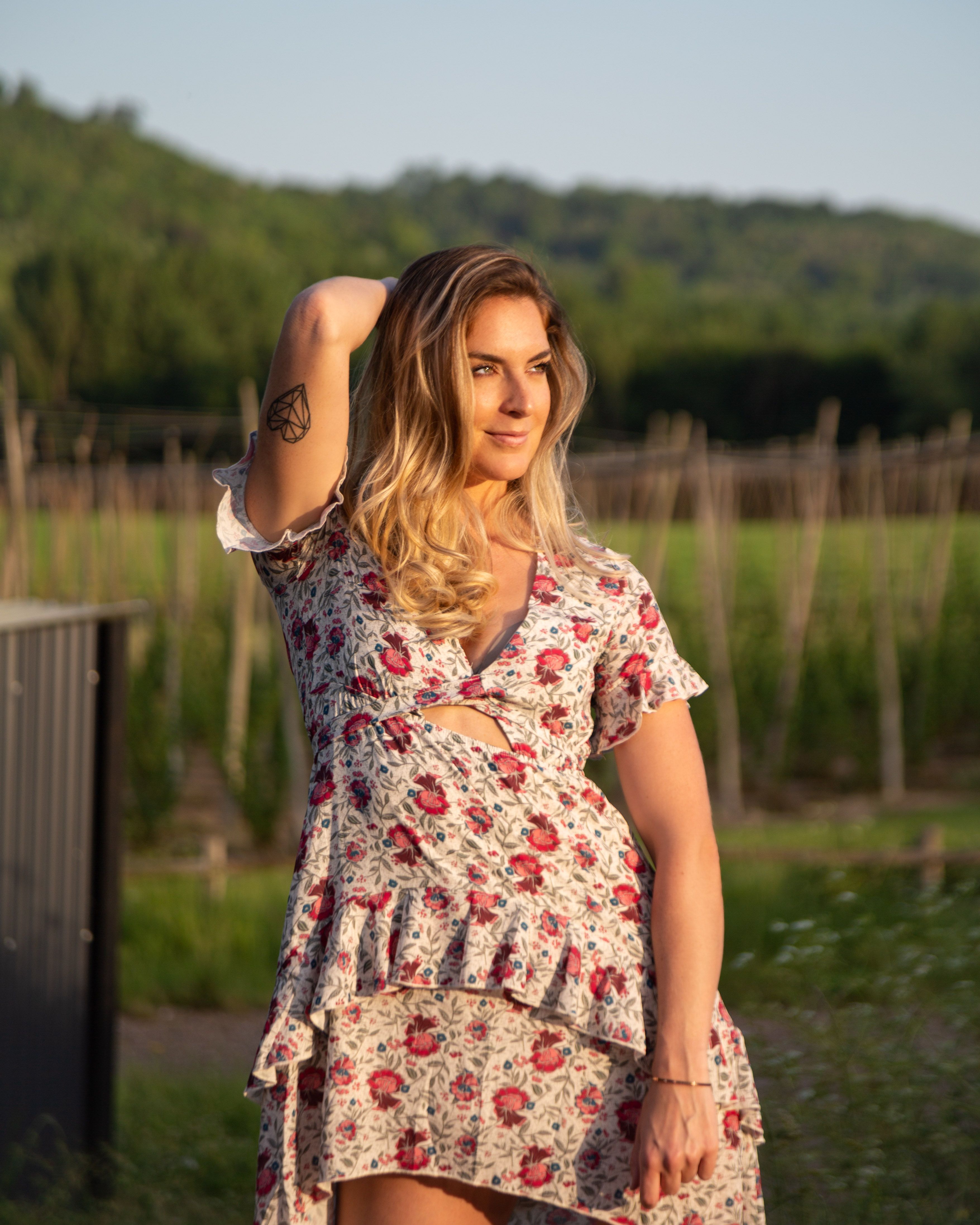 Woman in Red Floral Dress Standing on Grass Field · Free Stock Photo