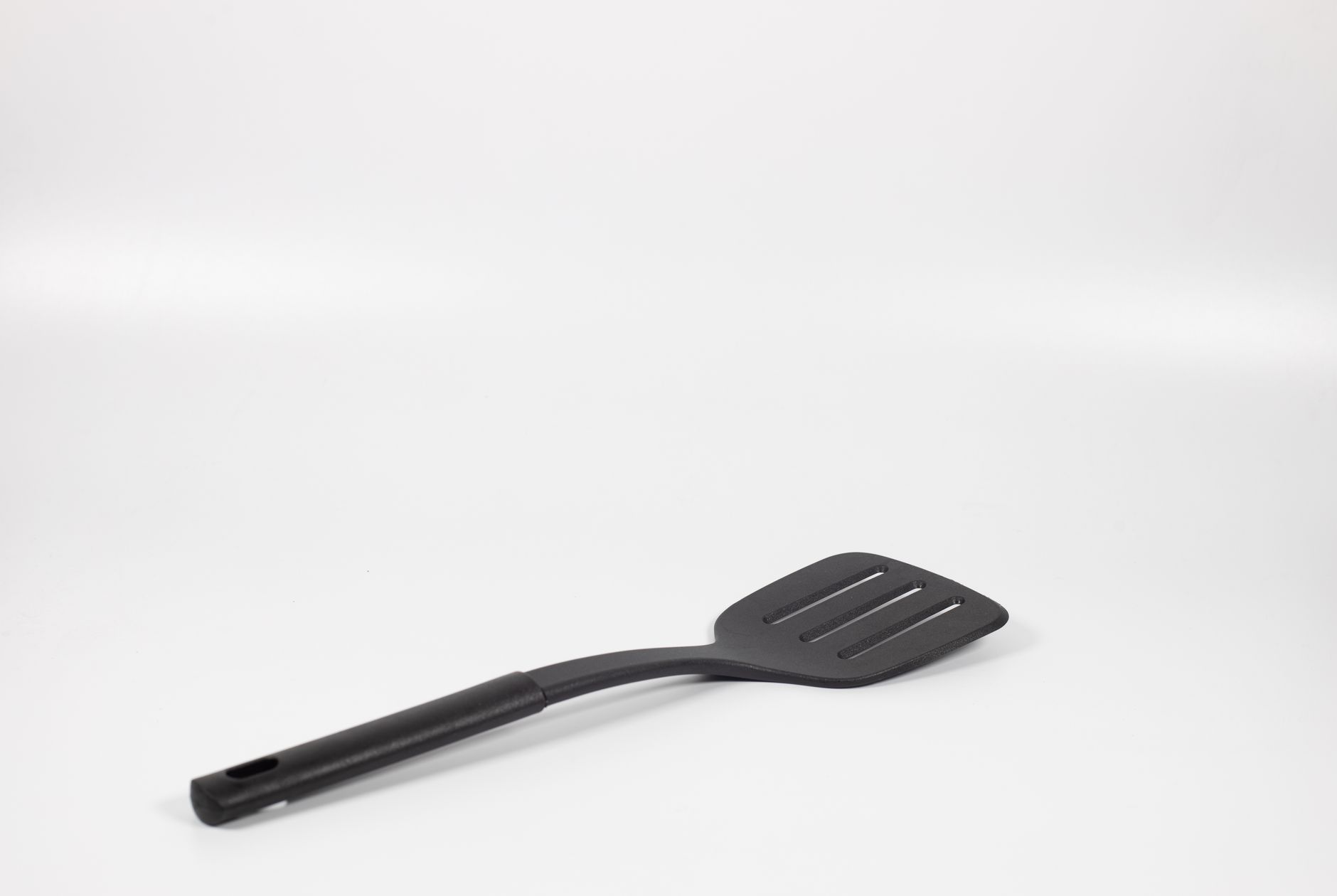 Simple black spatula utensil displayed on a white background with ample copy space.