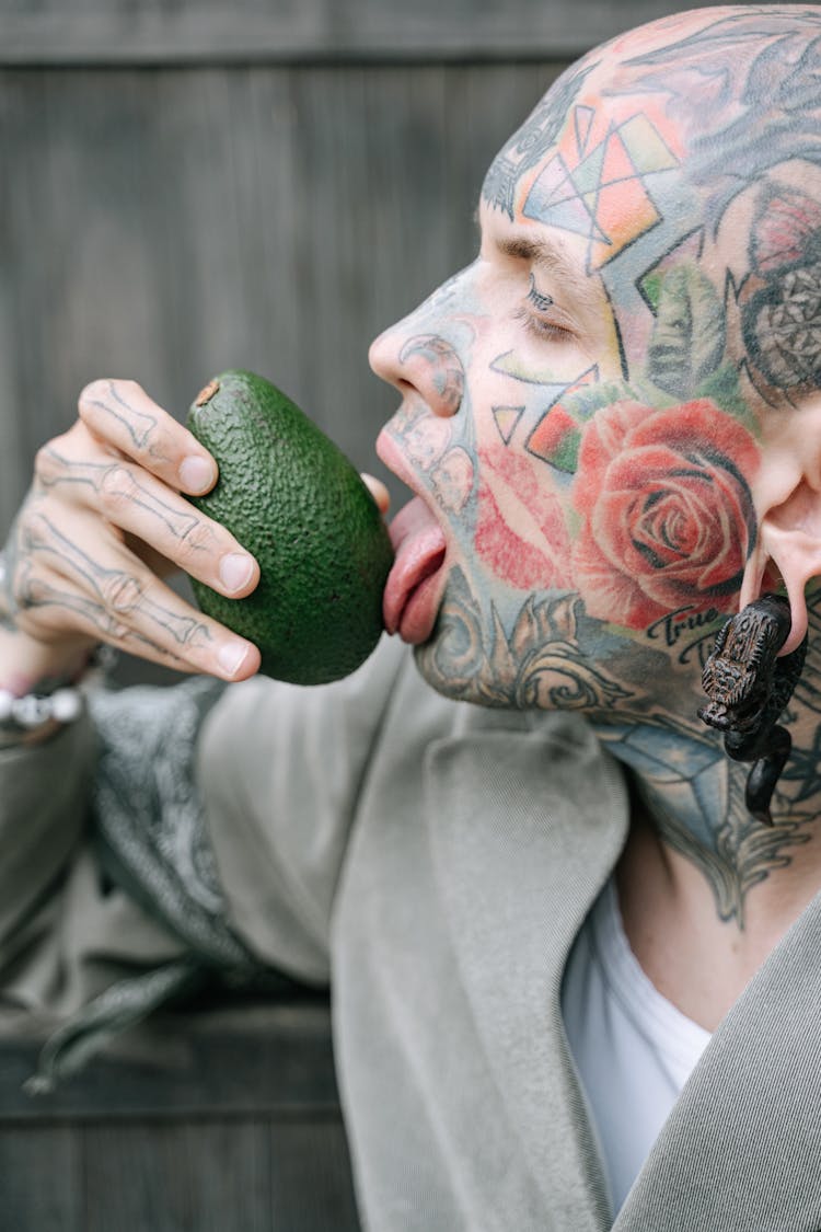 A Man Licking A Fruit