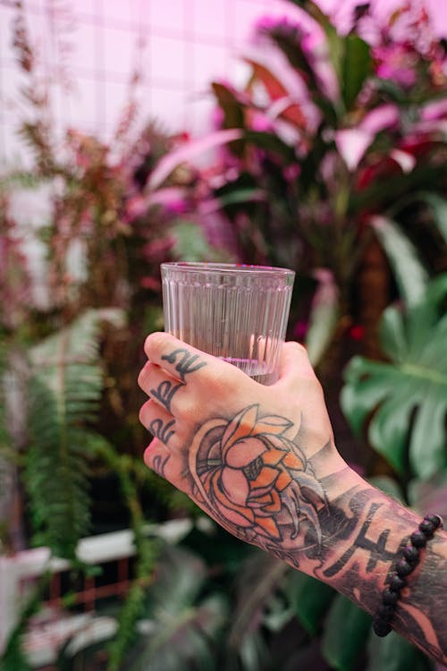 Drinking Glass held by a Tattooed Person 