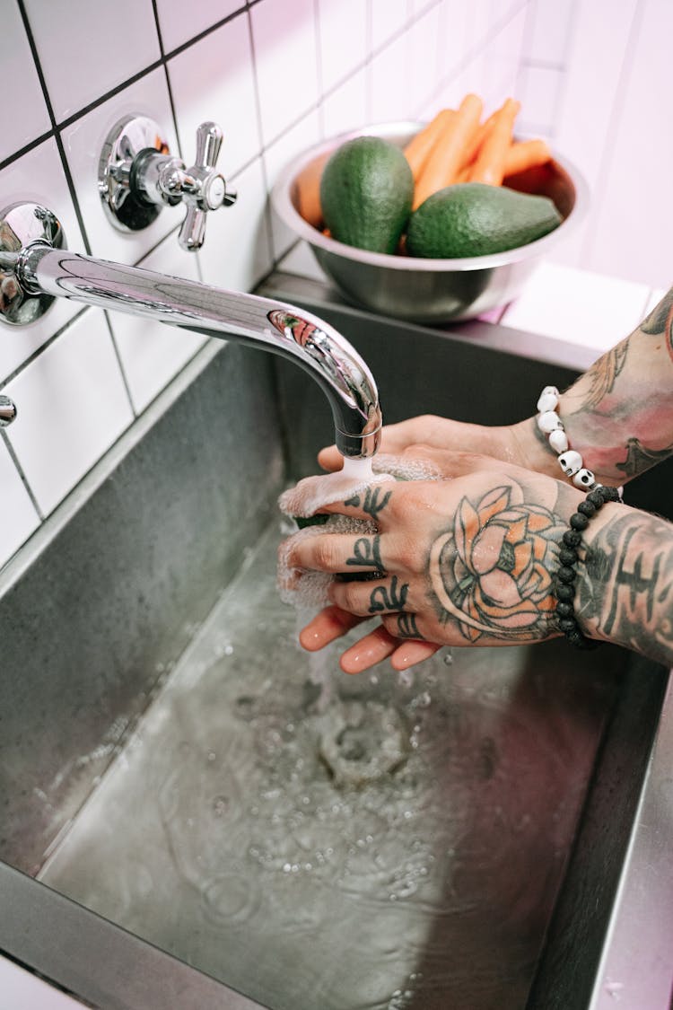 Person Washing His Hands On A Sink 