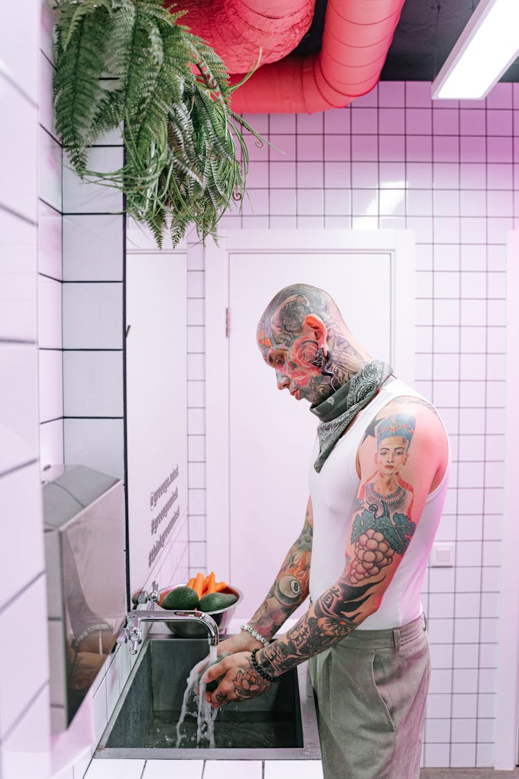 A Tattooed Man Washing His Hands