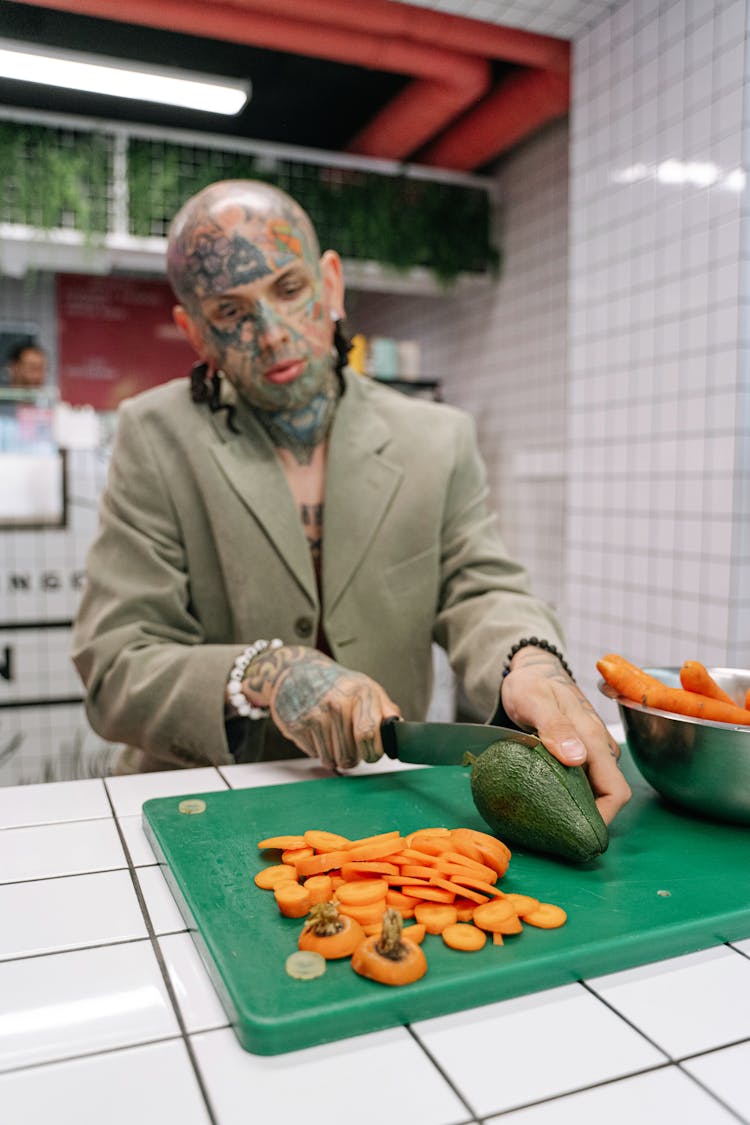 A Man In Brown Suit Slicing An Avocado