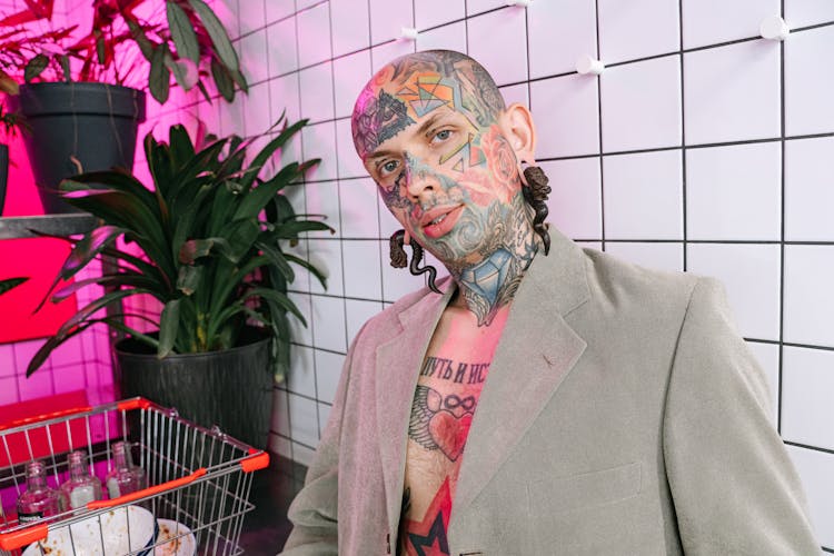 Man In Gray Blazer With Tattoo On Face