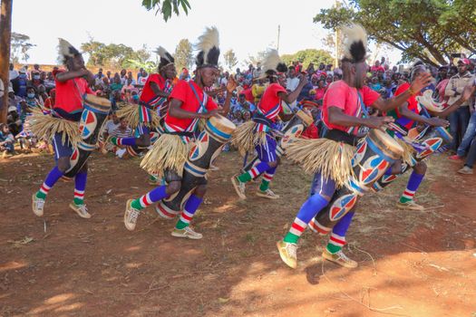 Vibrant scene of traditional drummers performing in lively cultural festival outdoors.