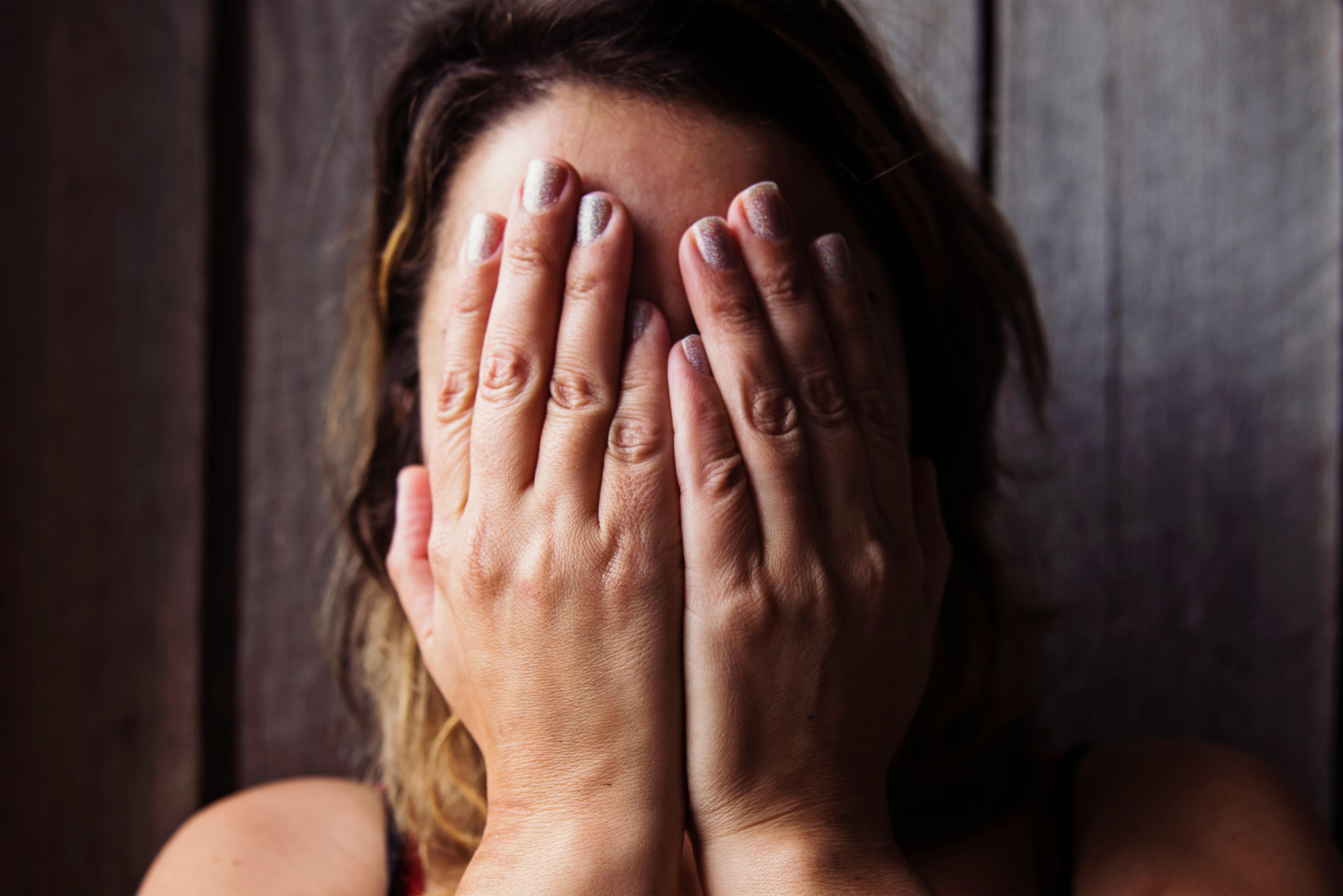 monochrome shot of a woman covering her face with her hands