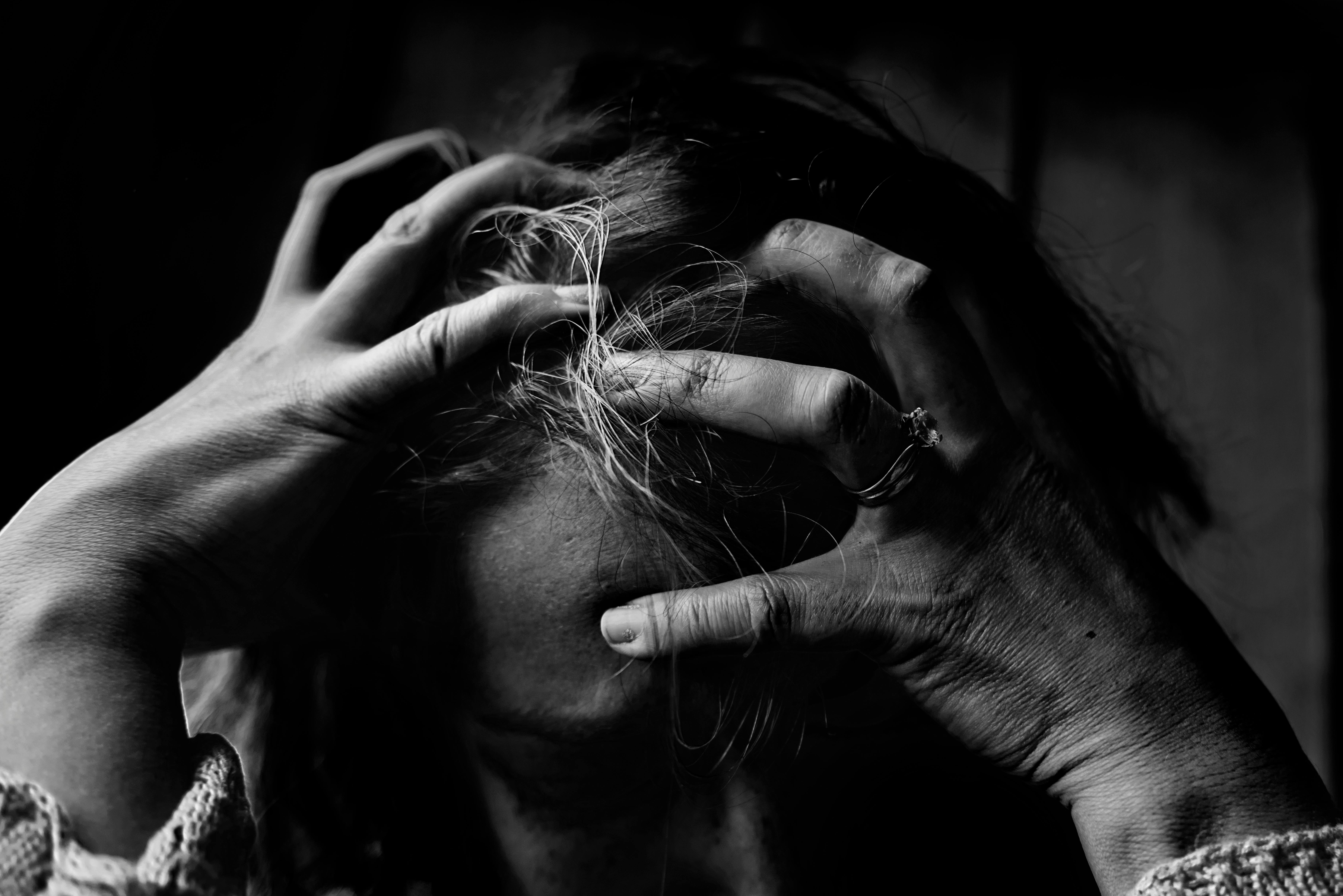 Woman holding her head | Photo: Pexels