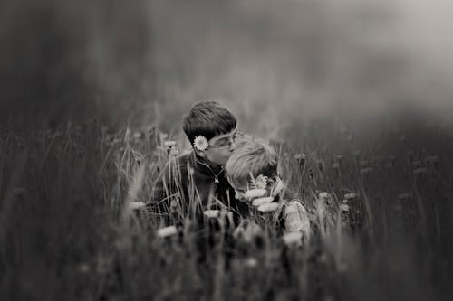 Boy Kissing Boy Head Surrounded by Flowers