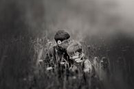 Boy Kissing Boy Head Surrounded by Flowers