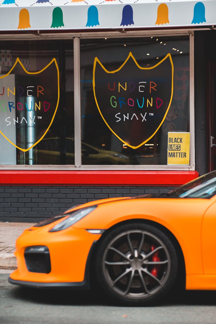 Luxury Sports Car On Road Near City Building