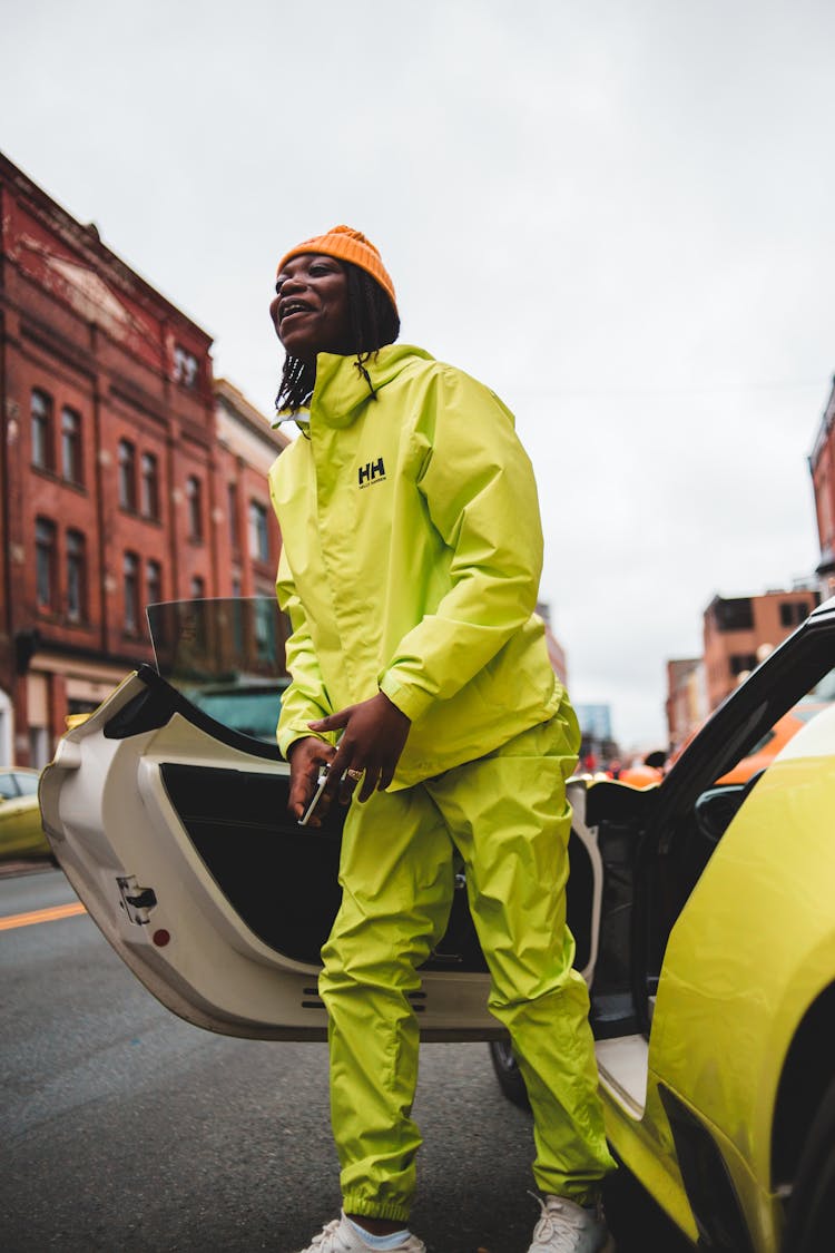 Content African Man With Smartphone Near Luxury Car In City