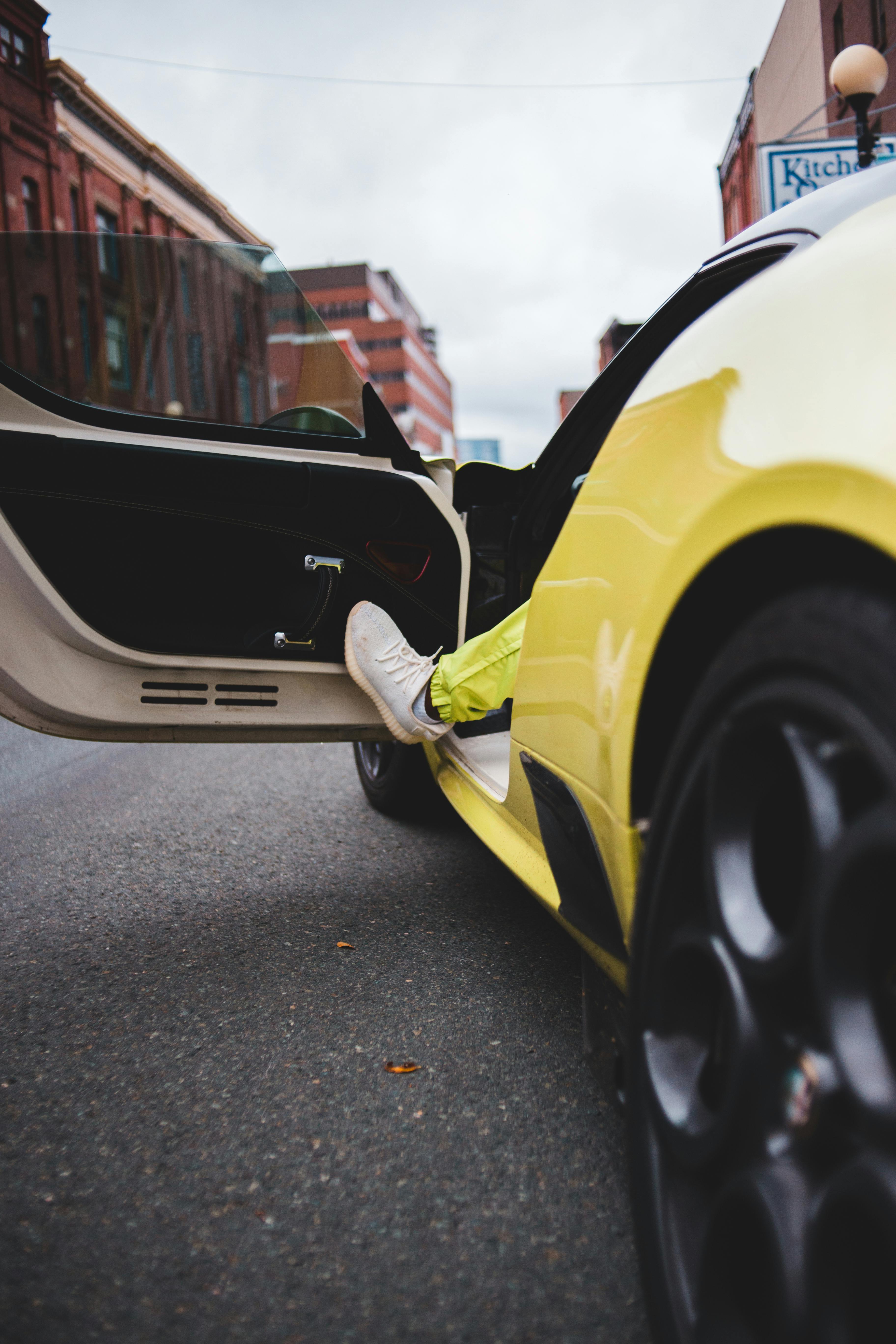 unrecognizable driver opening door of luxury sports car