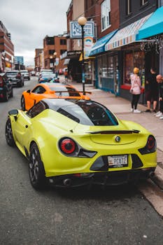 Luxury automobile parked on asphalt road near pavement with people on cloudy day in summer