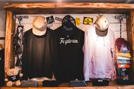 Colorful trendy clothes hanging on counter with wooden elements in stylish store in daytime
