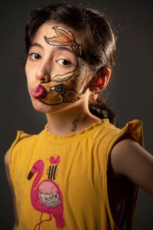 Free A young girl poses with creative face paint in a colorful portrait. Stock Photo