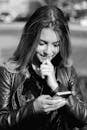 A Woman in a Leather Jacket Looking at Her Phone