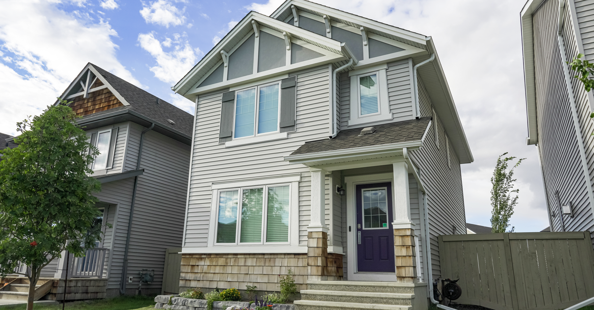 Front exterior of a contemporary suburban home with a porch under a clear blue sky