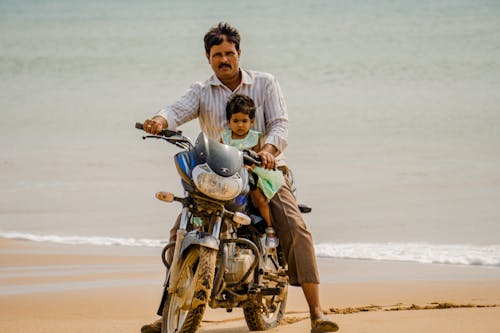 Man With Daughter on Motorbike on Beach