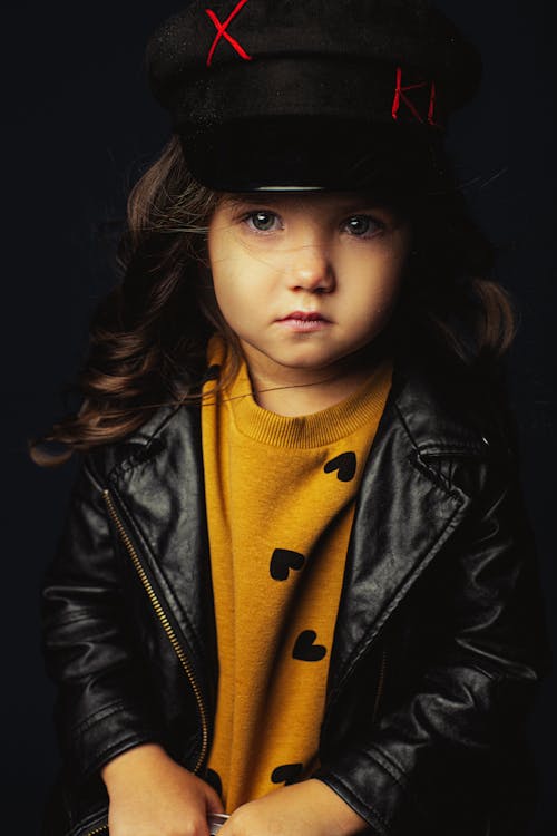 Close-Up Photo of a Young Girl in a Black Leather Jacket Looking at the Camera