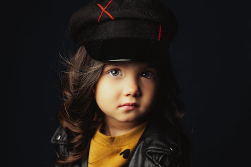 Close-Up Photo of a Cute Girl Wearing a Black Cap