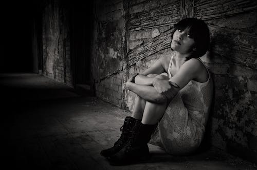 Monochrome Photo of a Woman in a Dress Sitting on the Floor