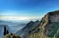 在晴朗的蓝天下，蒙塞拉特山脉绿树成荫，风景一览无余