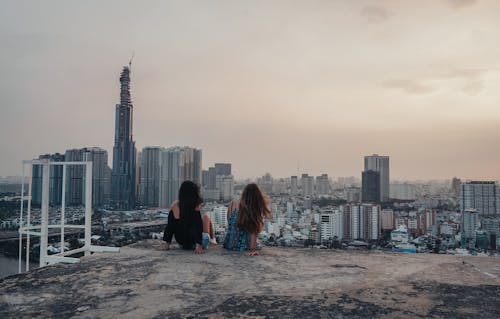 Women Sitting on the Rooftop while Looking at the City View