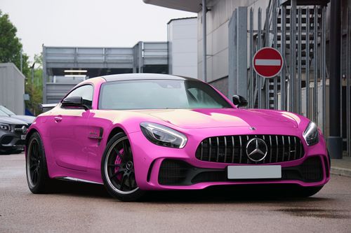 Free Bright pink luxury sports car parked on a city street in the UK. Modern automotive design. Stock Photo