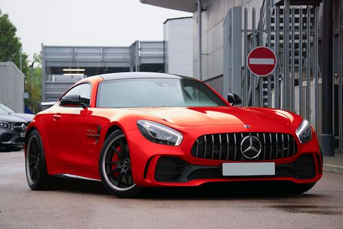 Free Close-up of an orange sports car parked on a wet street in the UK. Luxury vehicle with dynamic appeal. Stock Photo