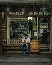 Man in White Shirt and Blue Denim Jeans Sitting on Brown Wooden Seat