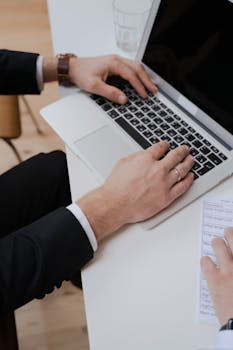 High-angle shot of a person typing on a laptop at a desk, ideal for business and technology themes.