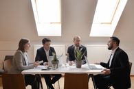 Group of People Sitting on Chair in Front of Table