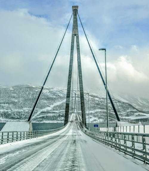 Gray Concrete Bridge over Snow Covered Mountain