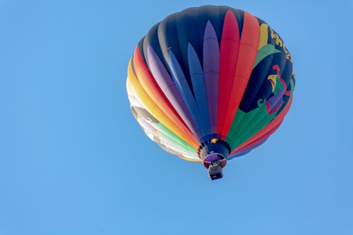 Low Angle Shot of a Colorful Hot Air Balloon Flying against Blue Sky 