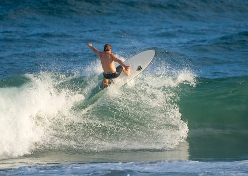 A Shirtless Man Surfing 