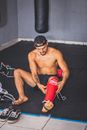 Topless Man Wearing Black Sunglasses Holding Red and Black Nike Boxing Gloves