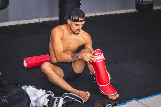Man gearing up with protective pads for martial arts.