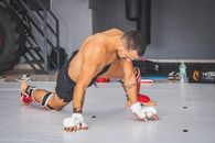 Man in Black Tank Top and White Nike Socks Sitting on Floor