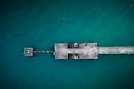 Concrete shabby abandoned pier in endless ocean