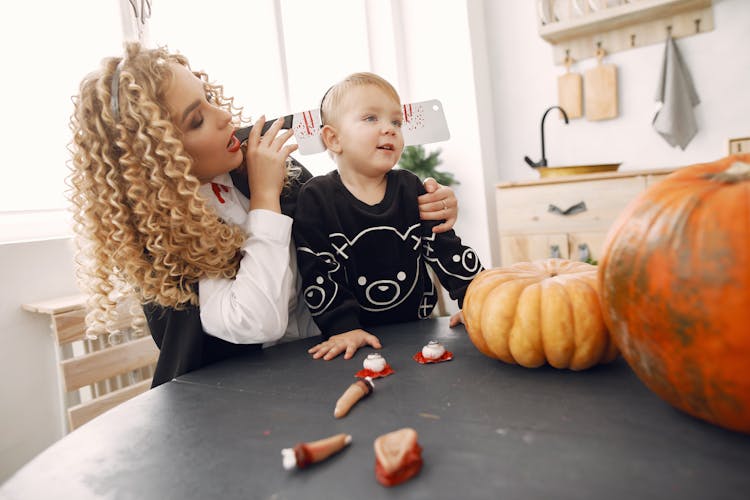 Mother Dressing Up Son In Halloween Costume