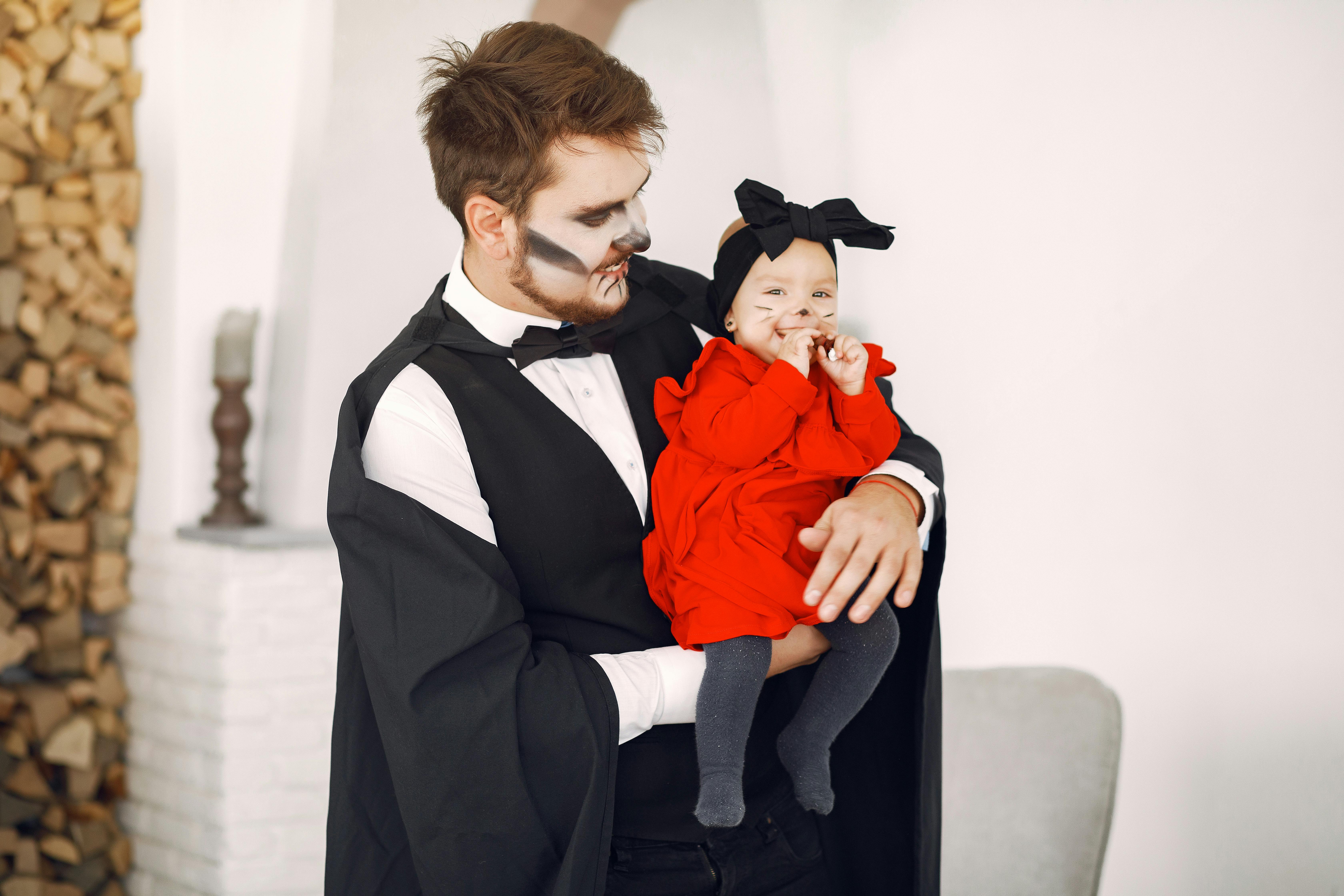 father carrying his baby while wearing their halloween costumes